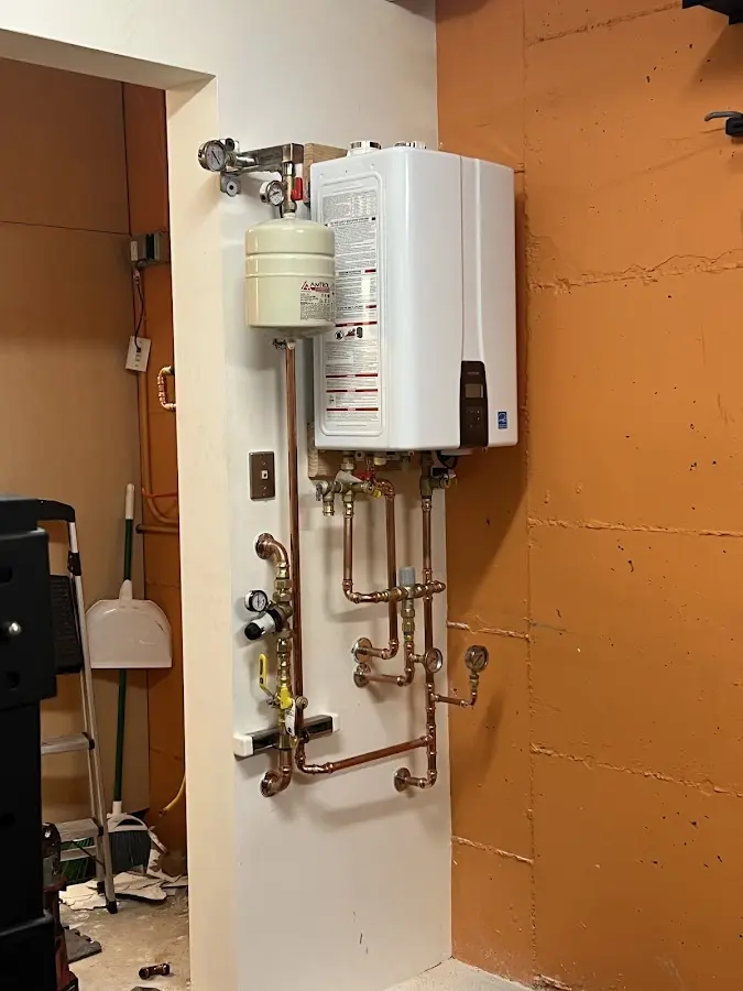 Plumbing technician inspecting water heater connections in Noble